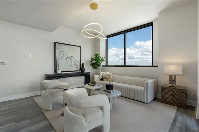 a living room with furniture large windows and wooden floor