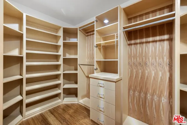 a view of walk in closet with empty racks