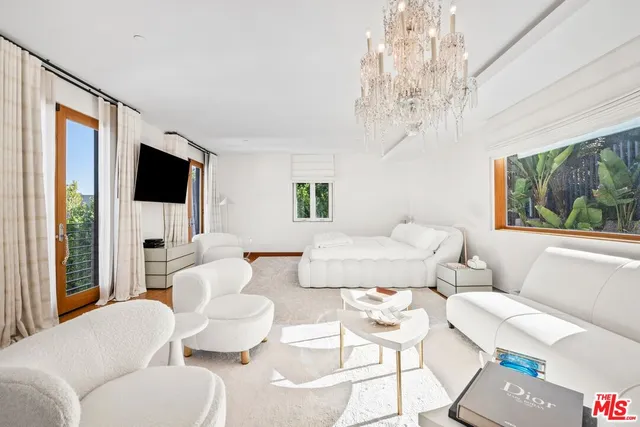 a living room with furniture a flat screen tv and a large window