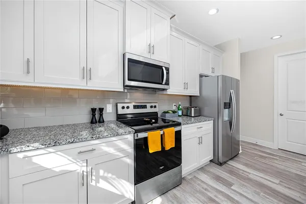 a kitchen with stainless steel appliances granite countertop a refrigerator stove microwave and sink