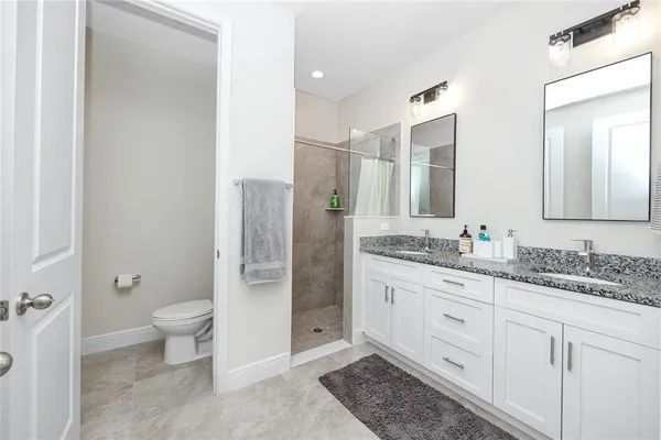 a bathroom with a granite countertop sink toilet and shower