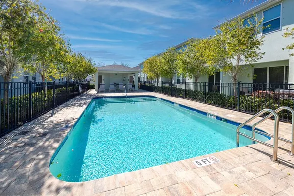 a view of a backyard with a patio and swimming pool