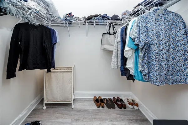 a view of walk in closet with clothes and shoes