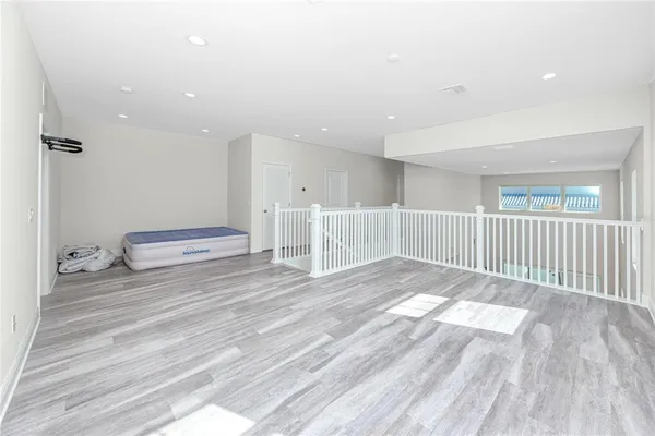 a view of a hallway with wooden floor and chandelier