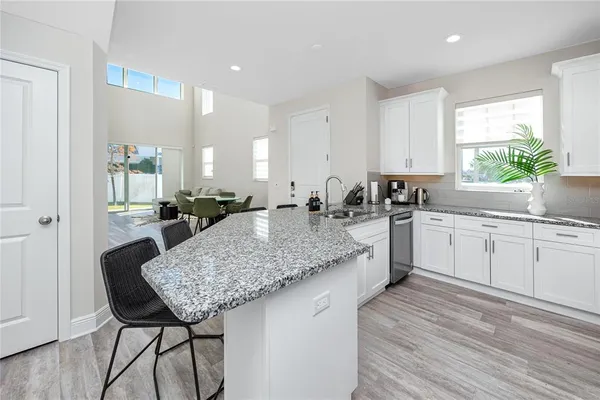 a kitchen with a table chairs sink and cabinets