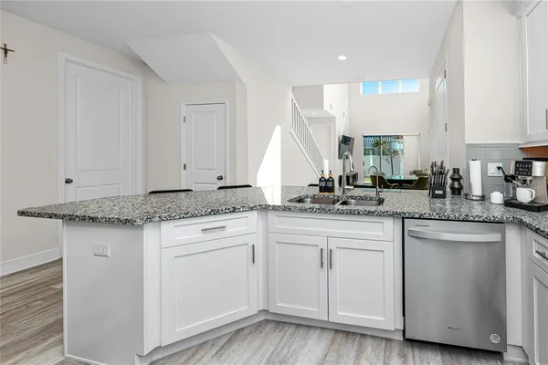 a kitchen with white cabinets appliances and a sink