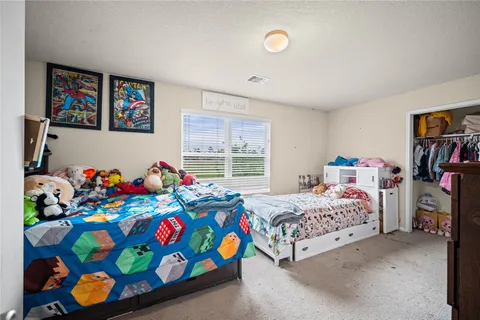 a bedroom with a bed a dresser and book shelf