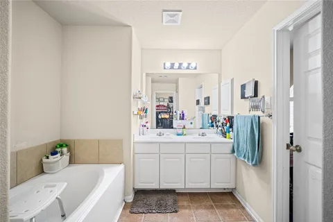 a bathroom with a sink and mirror with bathtub