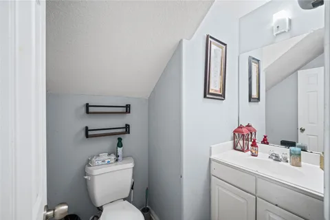 a bathroom with a toilet sink vanity and mirror