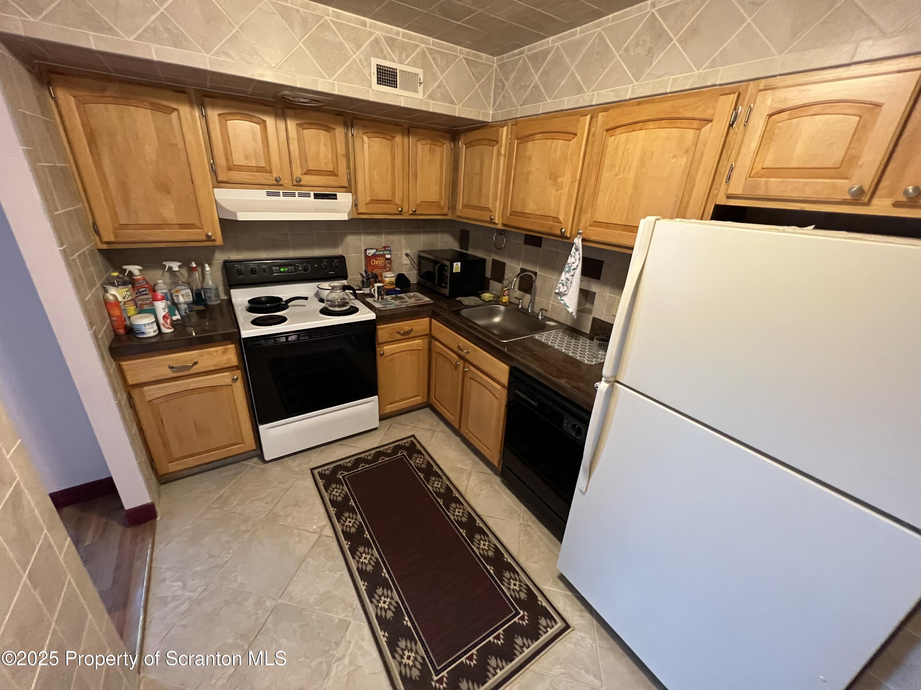 220 Linden Street, Unit 604 Scranton, PA 18503 - Photo 3 of 9 a kitchen with stainless steel appliances a stove a sink and a refrigerator