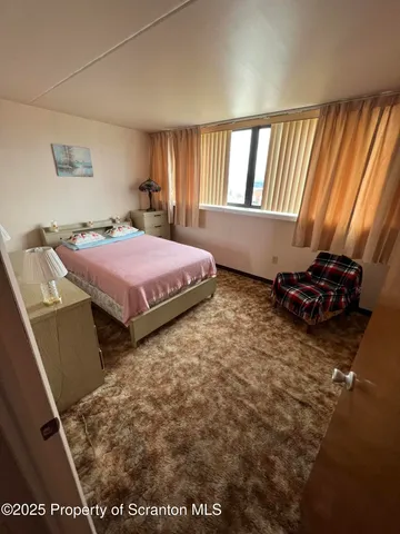 a spacious bedroom with a bed and a window