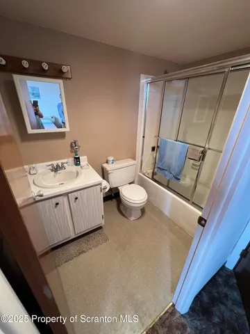 a utility room with a sink a toilet and a vanity
