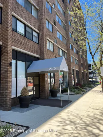 a couple of table and chairs in front of brick building