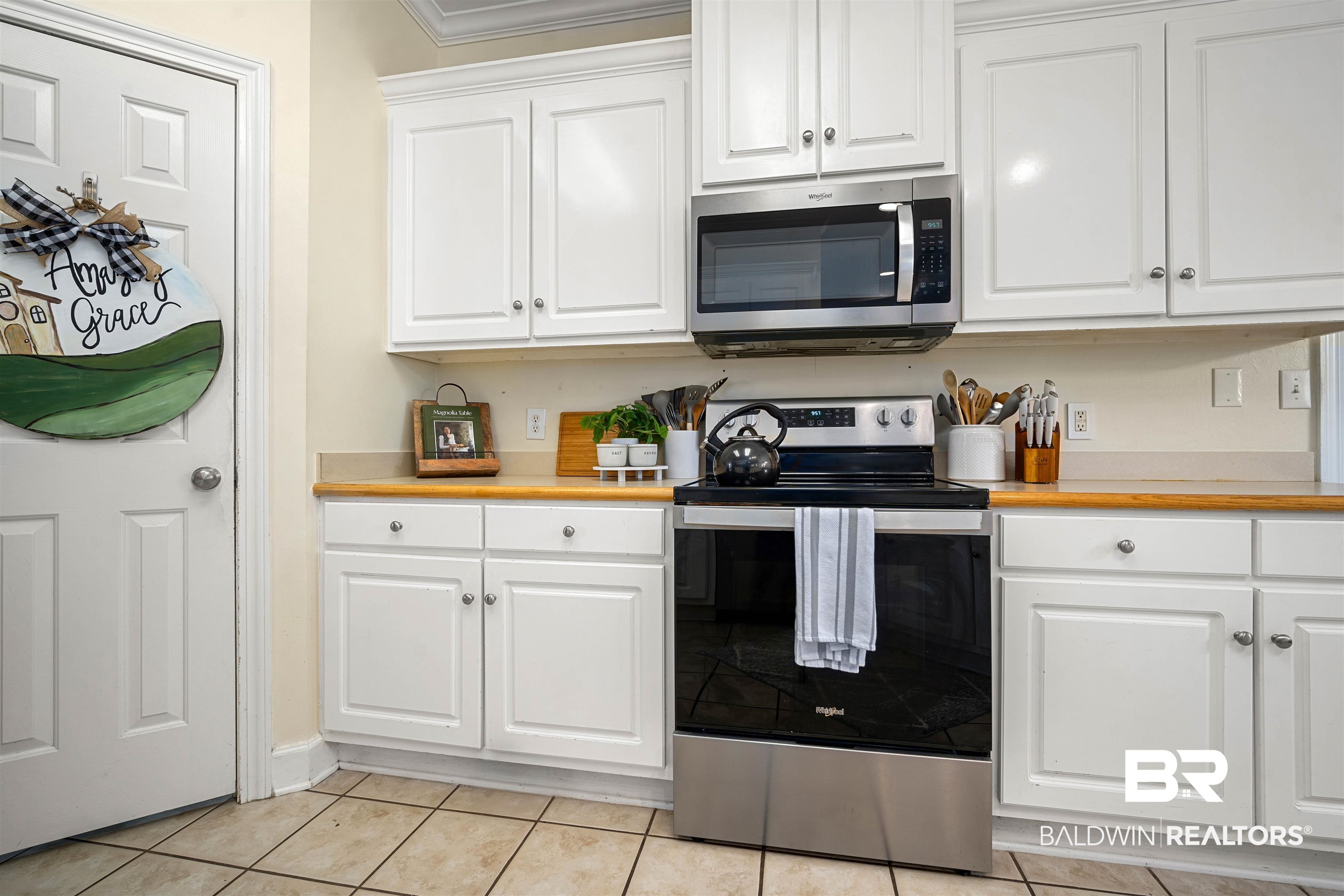 9552 White Castle Road Mobile, AL 36695 - Photo 10 of 31 Kitchen featuring stainless steel appliances, white cabinetry, crown molding, light countertops, and light tile floors