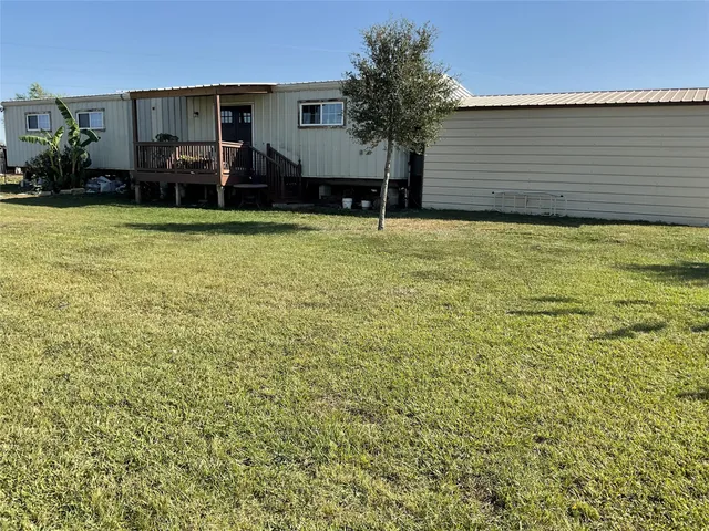 a view of a house with backyard and a tree