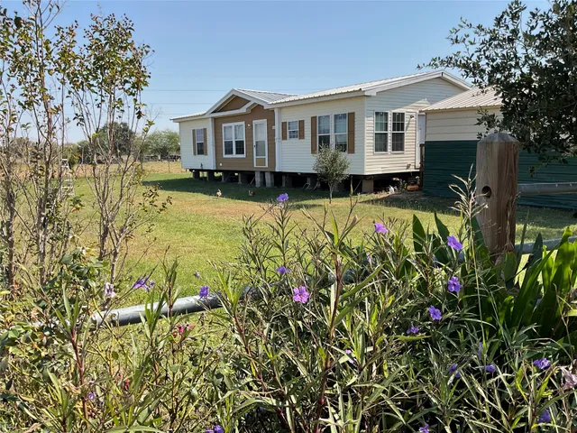 a front view of a house with a yard and fountain in middle
