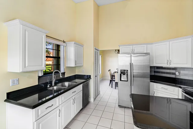 a kitchen with granite countertop a refrigerator and a sink