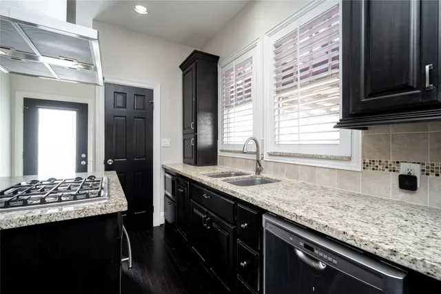 a kitchen with stainless steel appliances granite countertop a sink stove and cabinets