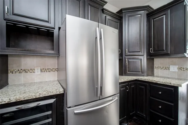 a kitchen with granite countertop a refrigerator and a sink
