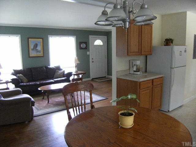 3015 Brentwood Road Raleigh, NC 27604 - Photo 2 of 12 a living room with furniture a chandelier and a wooden floor