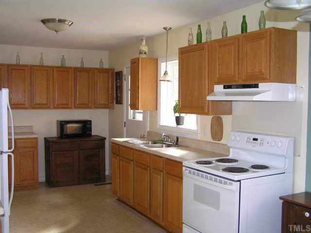 3015 Brentwood Road Raleigh, NC 27604 - Photo 4 of 12 a kitchen with a sink a stove and a refrigerator