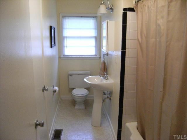 3015 Brentwood Road Raleigh, NC 27604 - Photo 9 of 12 a bathroom with a sink toilet and window