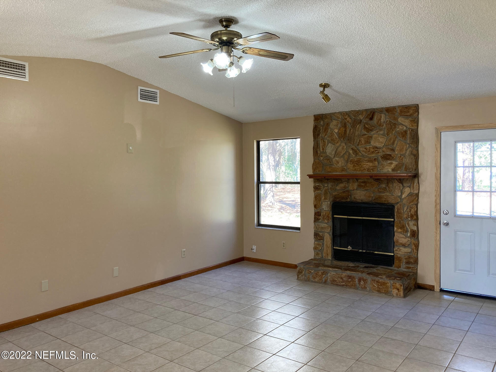 3970 Pinto Road Middleburg, FL 32068 - Photo 13 of 53 a view of a livingroom with a fireplace a ceiling fan and windows