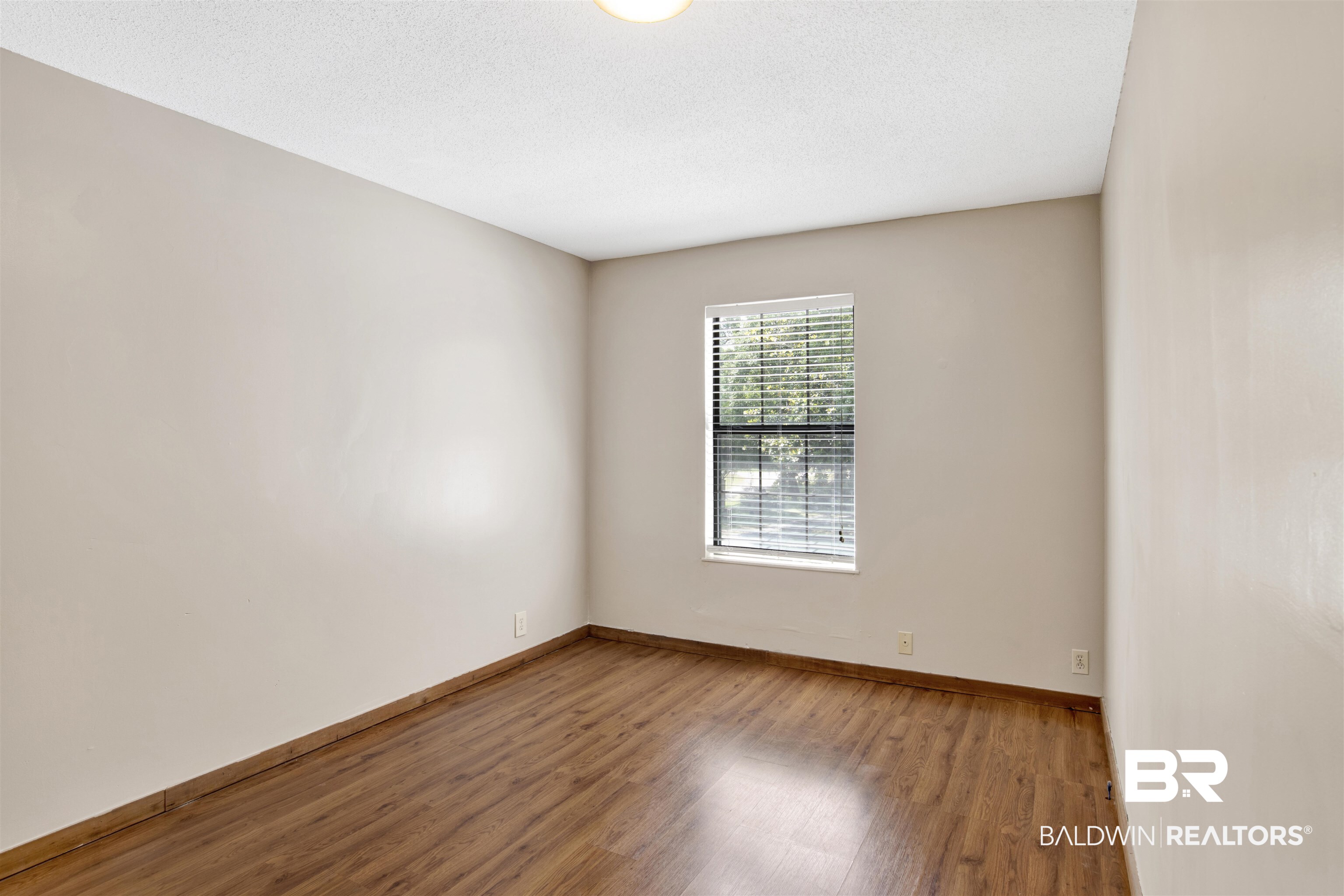 7411 Bay Road Mobile, AL 36605 - Photo 25 of 34 Empty room with light wood-type flooring and a textured ceiling