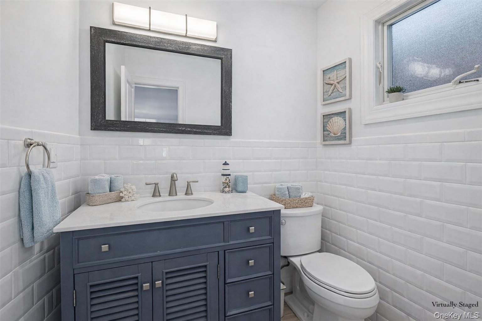 71 Michigan Street Long Beach, NY 11561 - Photo 13 of 48 a bathroom with a toilet sink and mirror