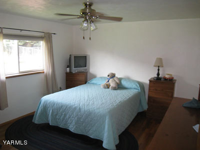704 Meadowbrook Road Yakima, WA 98903 - Photo 20 of 33 a bedroom with a bed and wooden floor