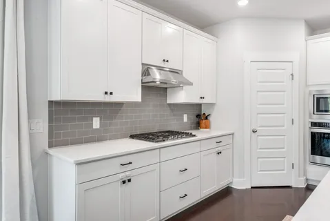 a kitchen with white cabinets and white appliances