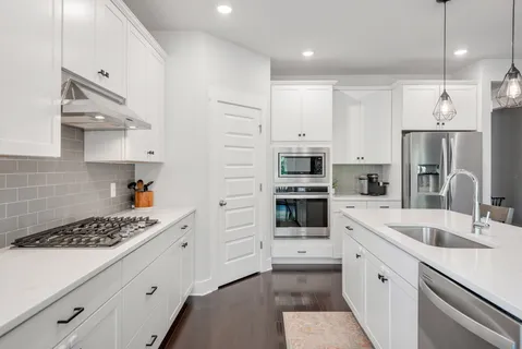 a kitchen with stainless steel appliances kitchen island granite countertop a sink stove and refrigerator
