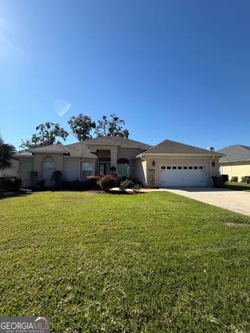 a front view of a house with a garden and car parked