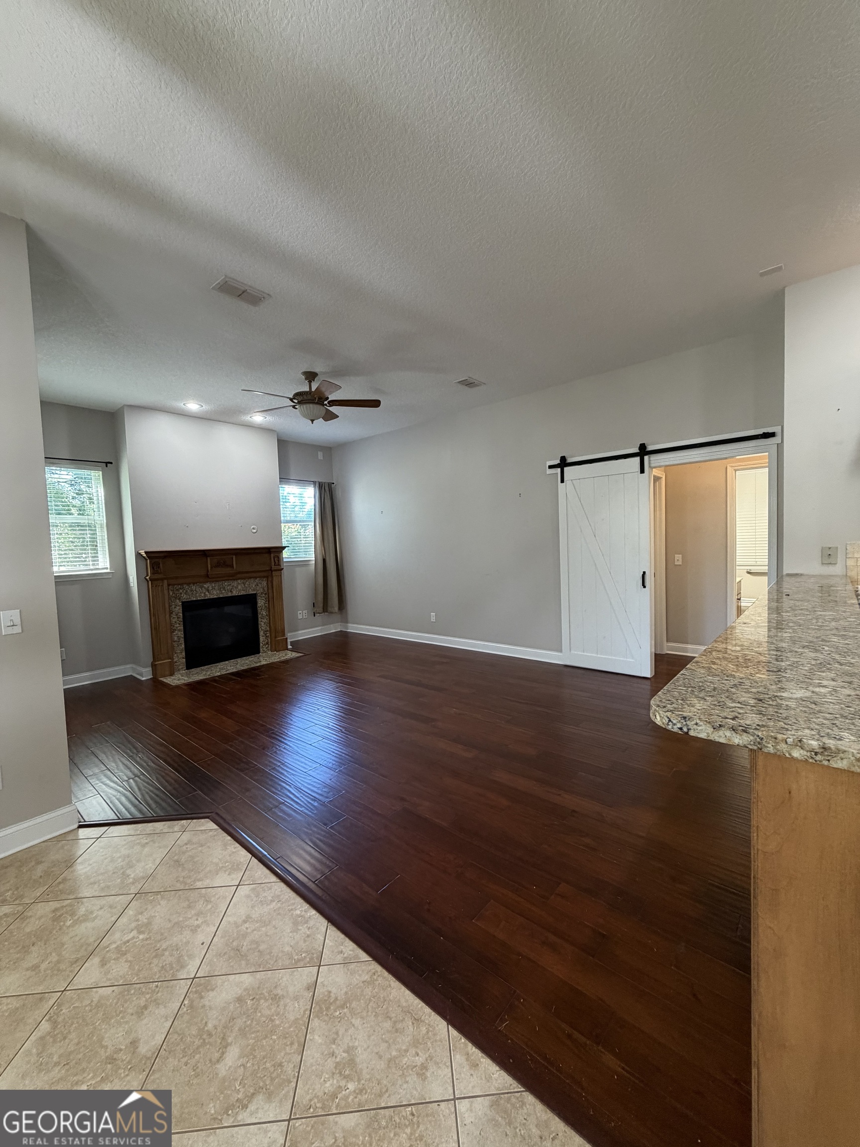 108 Heron's Nest Circle Kingsland, GA 31548 - Photo 16 of 62 an empty room with wooden floor fireplace and cabinet