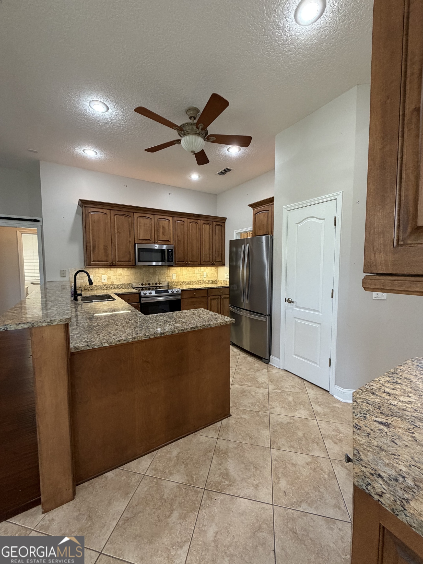 108 Heron's Nest Circle Kingsland, GA 31548 - Photo 19 of 62 a large kitchen with stainless steel appliances granite countertop a refrigerator and a sink