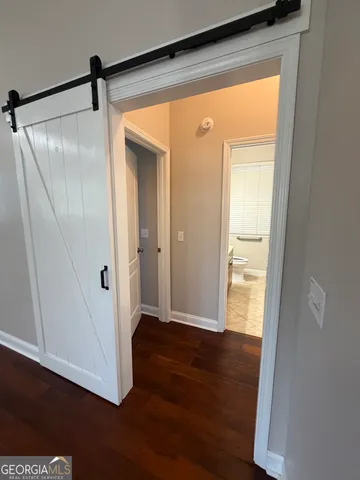 an empty room with wooden floor closet and fan