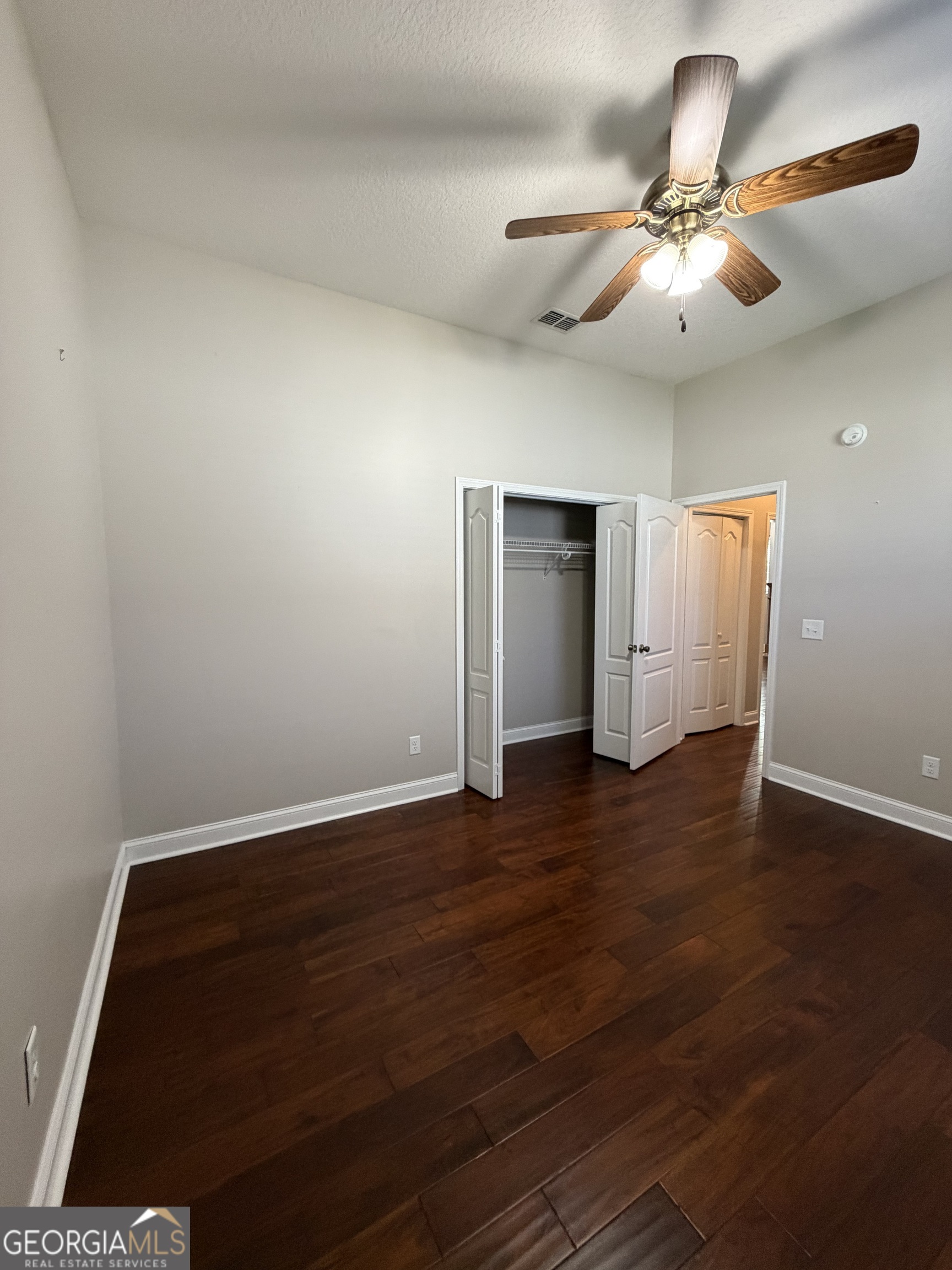 108 Heron's Nest Circle Kingsland, GA 31548 - Photo 51 of 62 an empty room with wooden floor chandelier fan and windows