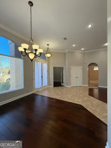 a view of a hallway with wooden floor and a living room