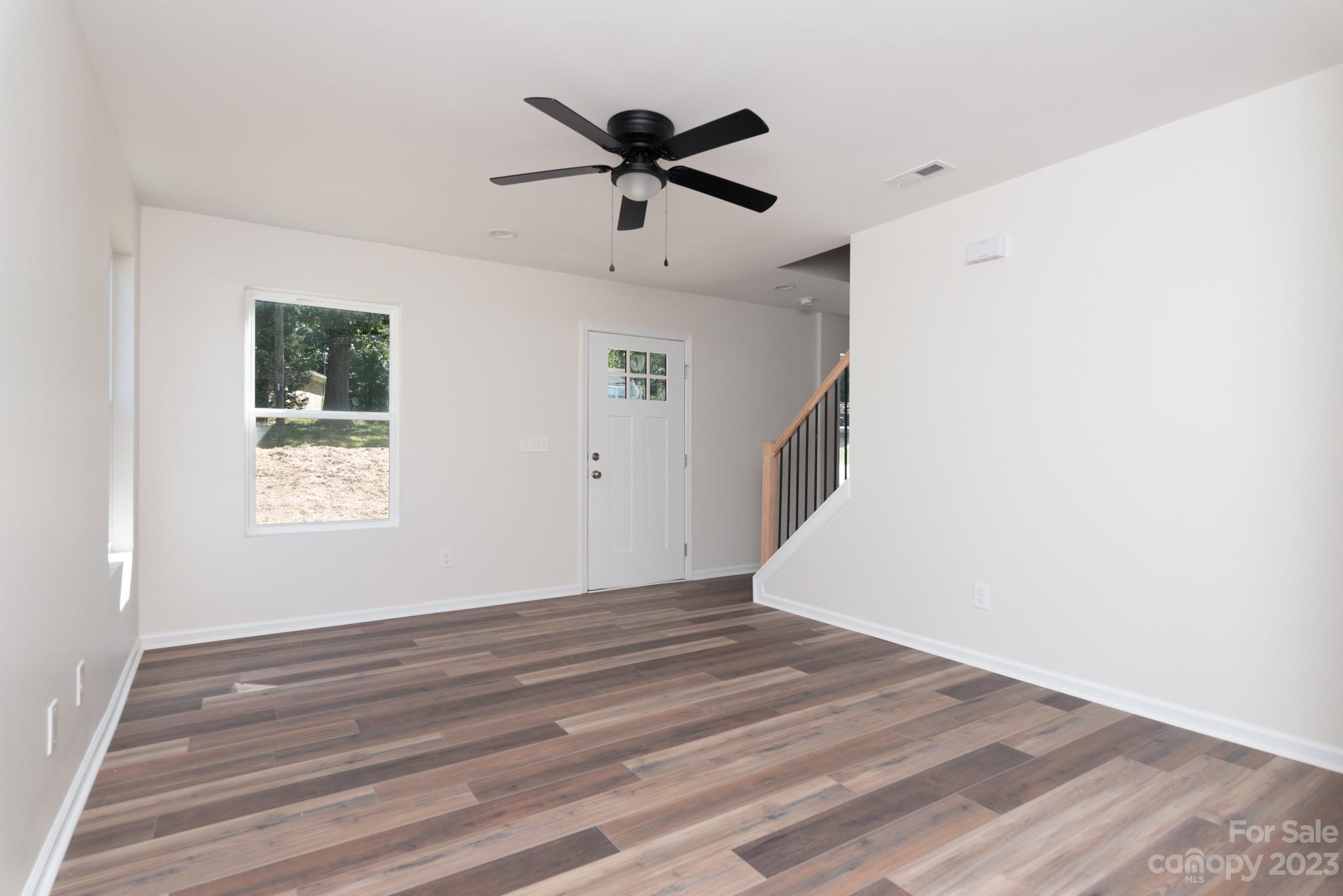 693 Gibson Drive Northwest Concord, NC 28025 - Photo 7 of 12 a view of a room with wooden floor and ceiling fan