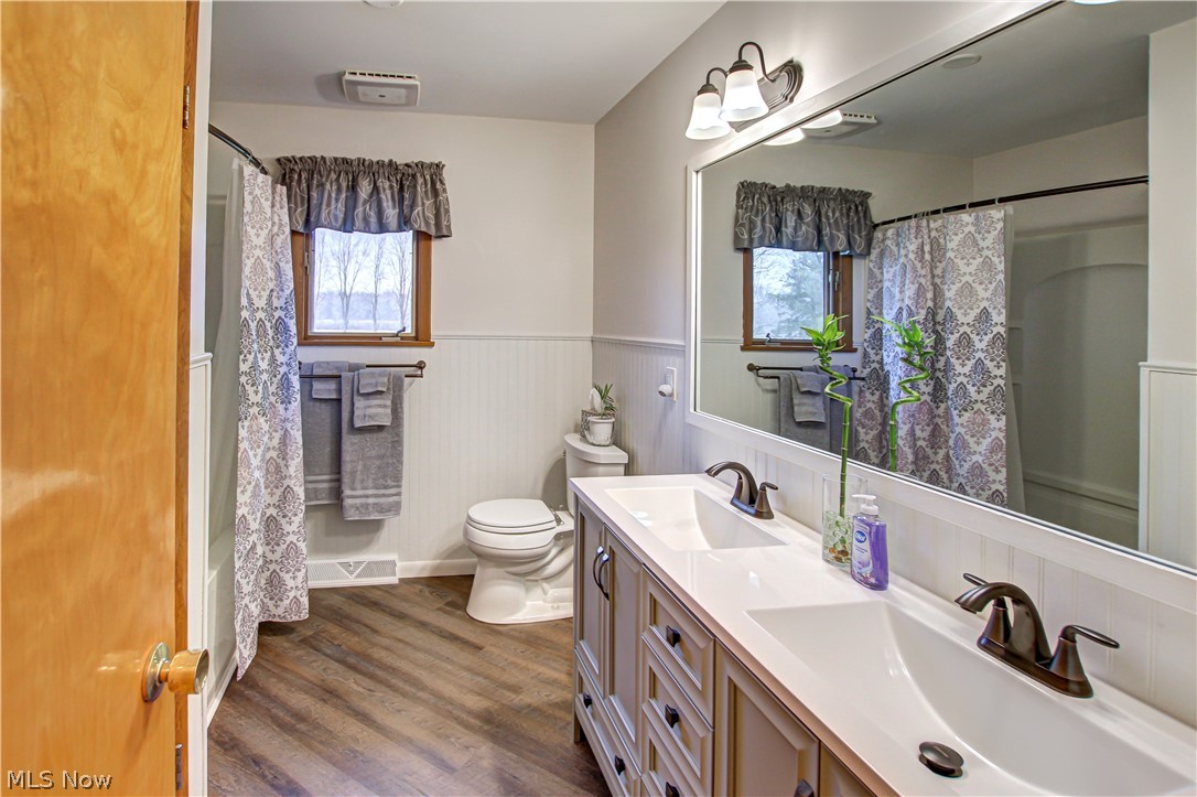 39974 Butternut Ridge Road Elyria, OH 44035 - Photo 19 of 40 Full bathroom featuring hardwood / wood-style floors, dual bowl vanity, toilet, and a healthy amount of sunlight