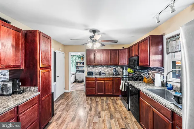 a kitchen with stainless steel appliances granite countertop sink stove top oven and cabinets