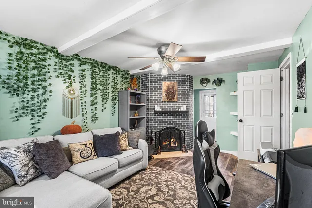 a living room with furniture a fireplace and a chandelier