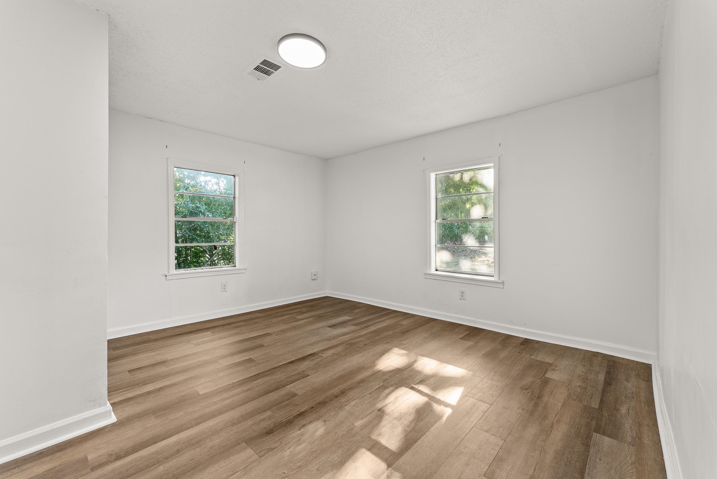 3736 Hawkins Mill Road Memphis, TN 38128 - Photo 27 of 29 an empty room with wooden floor and windows