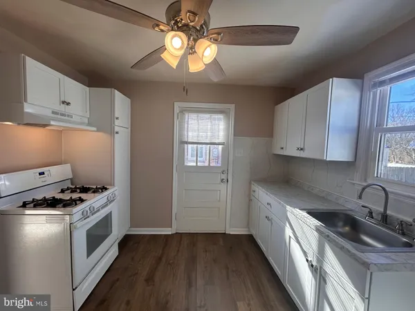 a kitchen with granite countertop a sink stainless steel appliances and cabinets