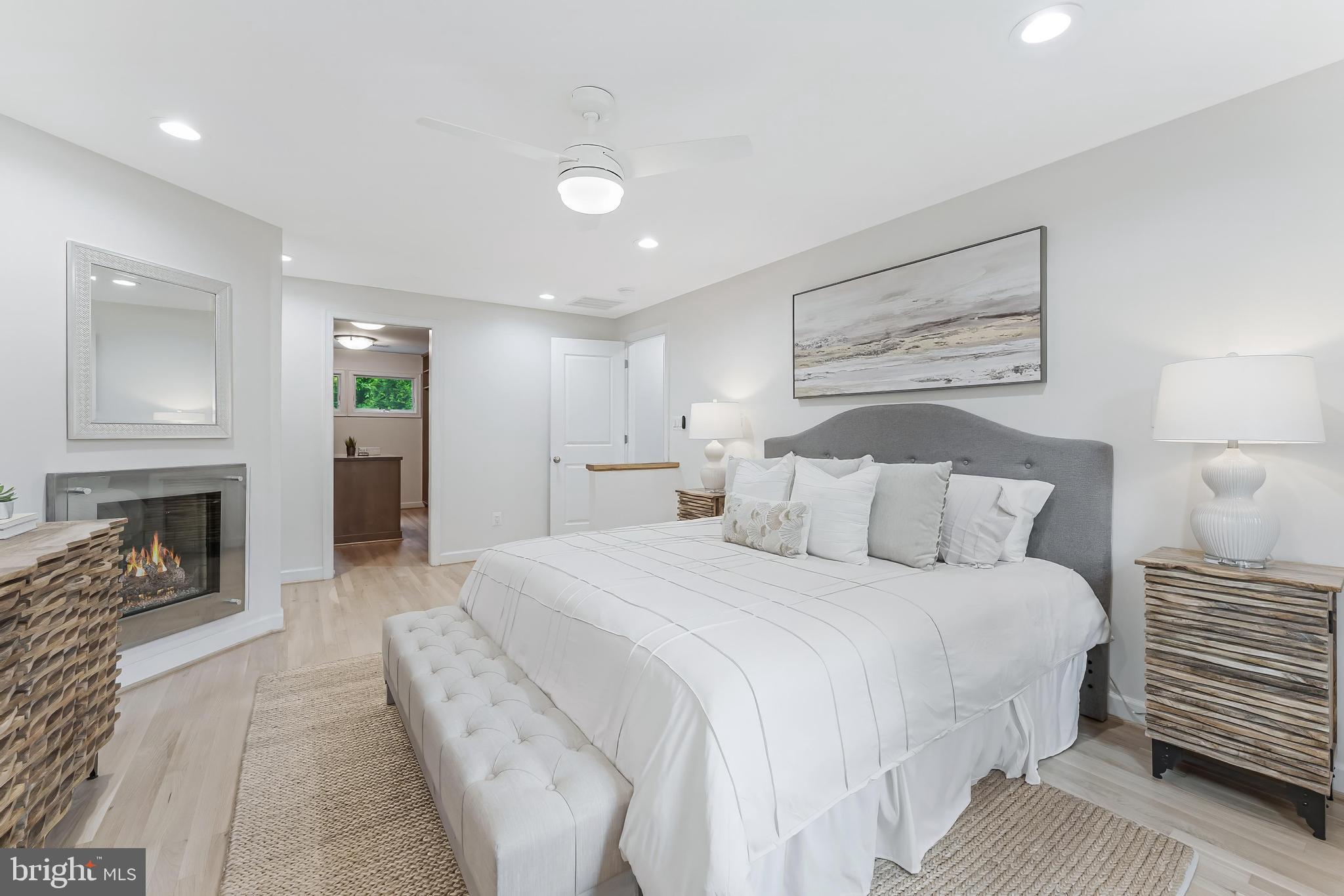 1655 Hunting Ridge Court McLean, VA 22101 - Photo 20 of 38 a spacious bedroom with a bed a fireplace and a couch