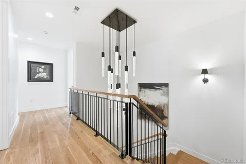 a view of a hallway with wooden floor and staircase