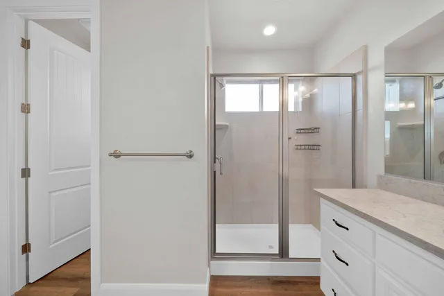 a bathroom with a glass shower door and a mirror
