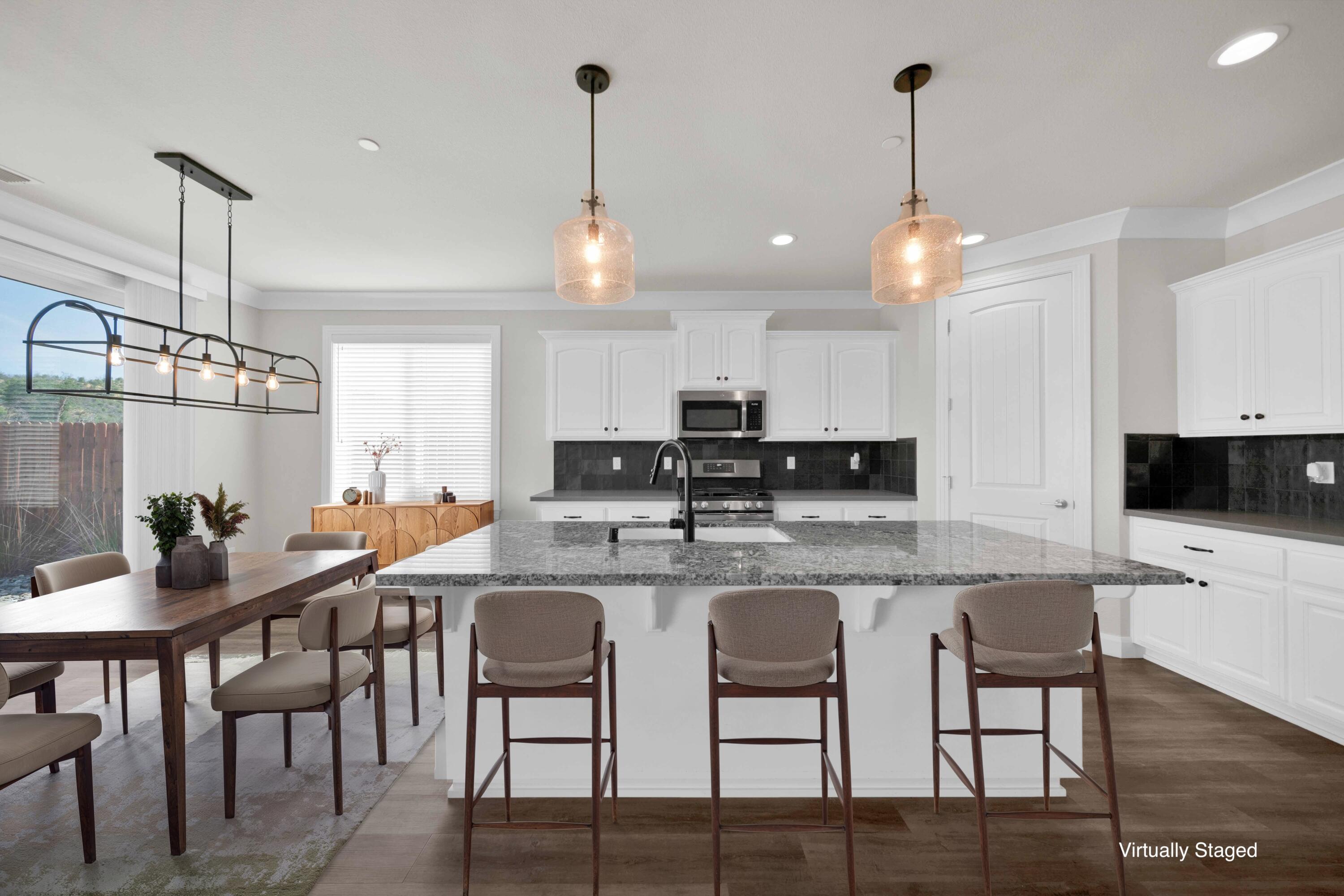 4771 Lower Springs Road Redding, CA 96001 - Photo 6 of 30 a kitchen with stainless steel appliances kitchen island granite countertop a dining table chairs and white cabinets