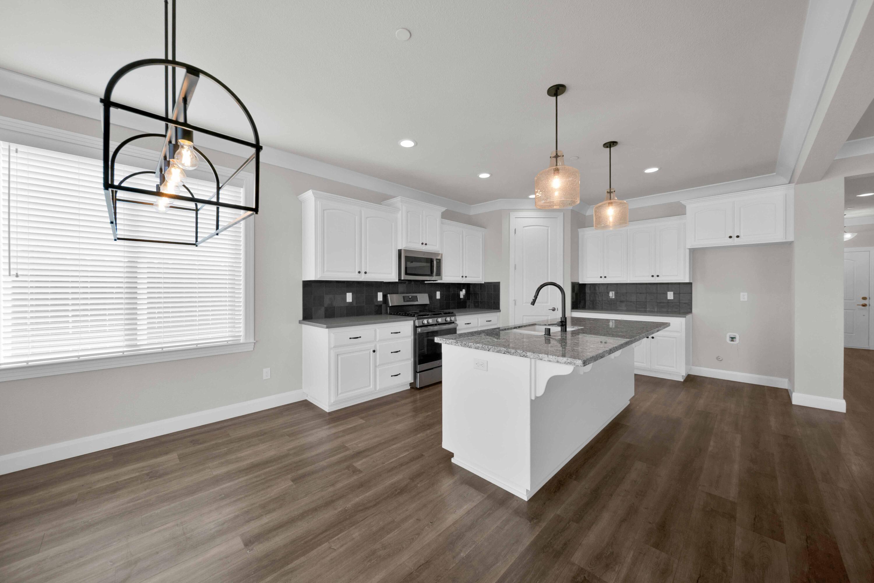 4771 Lower Springs Road Redding, CA 96001 - Photo 9 of 30 a large white kitchen with wooden floors and white cabinets
