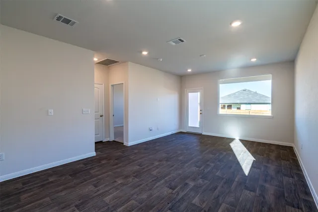 a view of an empty room with wooden floor